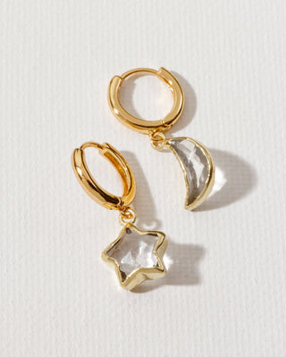 Gold hoop mismatched earrings with moon and star charms.