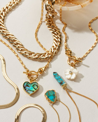 Collection showing gold abalone, turquoise, and quartz necklaces by Luna Norte.