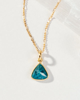 Close up of Apatite Bermuda Triangle Dainty Collar Necklace with a 14 Karat Gold Plated Brass chain laying on a white background.