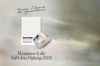 pantone swatch for cloud dancer and a raw moonstone gem overtop a moody cloud background feat the blog post title "From cloud to gemstone: moonstone & the soft glow defining 2026"