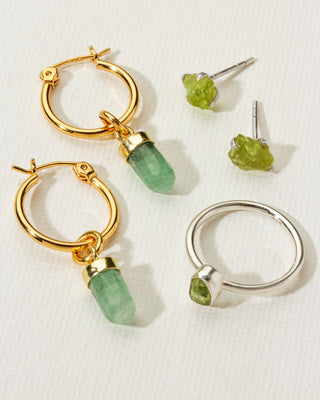 Sterling silver peridot ring and earrings next to green aventurine gold hoop earrings by Luna Norte.