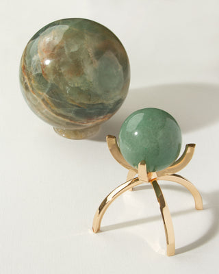 Two green crystal genuine stone spheres, one large and one smaller on a golden display stand.