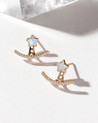 A pair of earrings featuring a post front back design with a star-shaped rainbow moonstone stud and a sparkling clear cz cluster ear jacket in gold plating.
