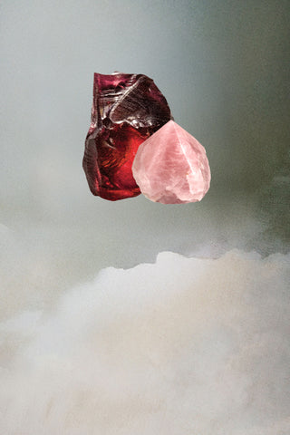 Raw garnet and rose quartz stones floating against misty clouds backdrop.