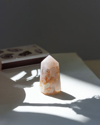 Polished agate tower on a light surface with a book in the background