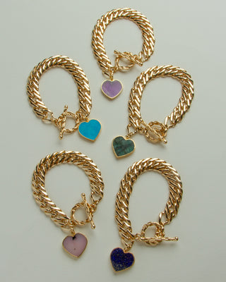 Five gold chain bracelets with toggle clasp and heart charms in different colors: purple, turquoise, emerald green, pink opal and lapis blue.