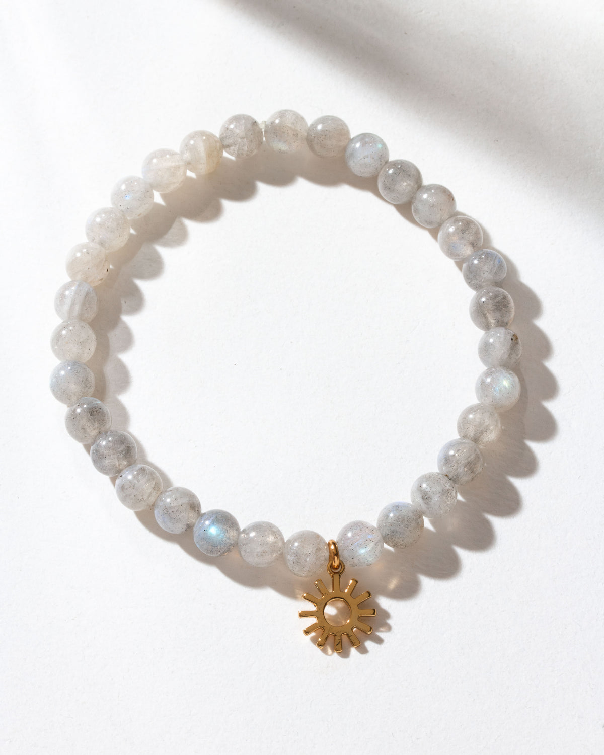 Labradorite beaded bracelet with a gold sunburst charm.