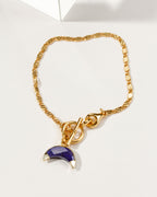 Gold Crescent Horn Toggle Bracelet with a Sapphire gemstone crescent horn charm.