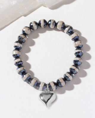 Bracelet with blue and white agate beads and a silver heart charm on a light background