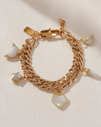 Gold charm bracelet with moonstone charms in moon, star, heart and prism shapes.