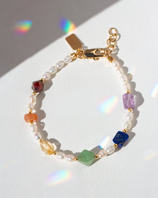 Multicolored beaded bracelet with gold clasp on a white background