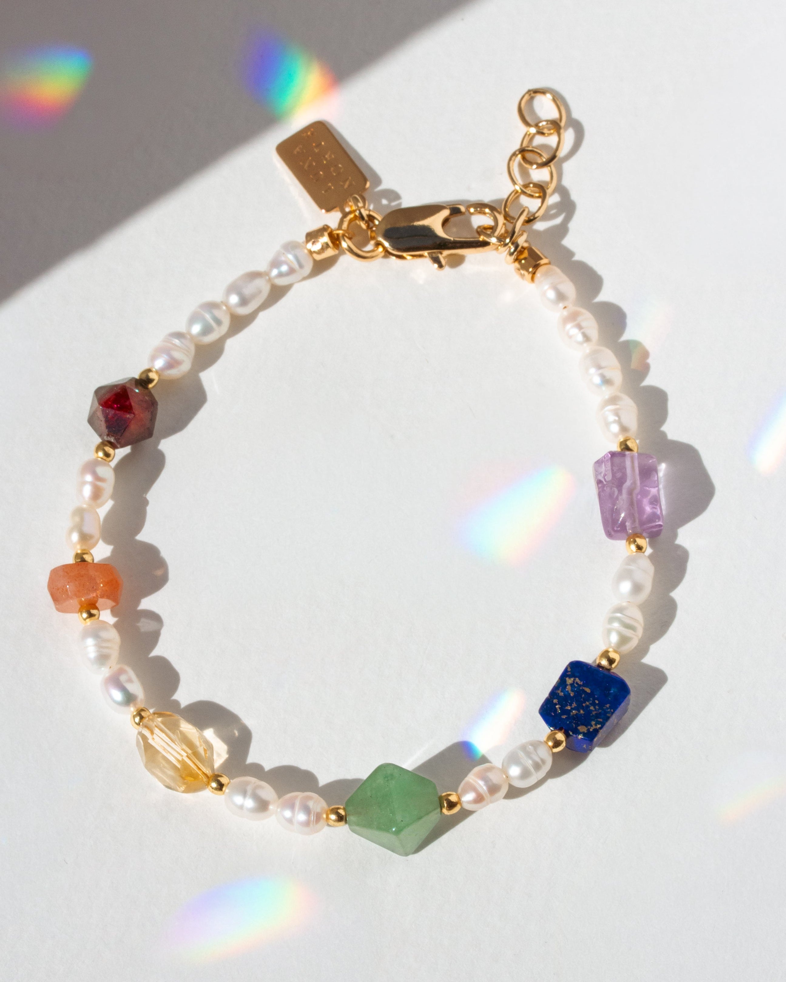 Multicolored beaded bracelet with gold clasp on a white background