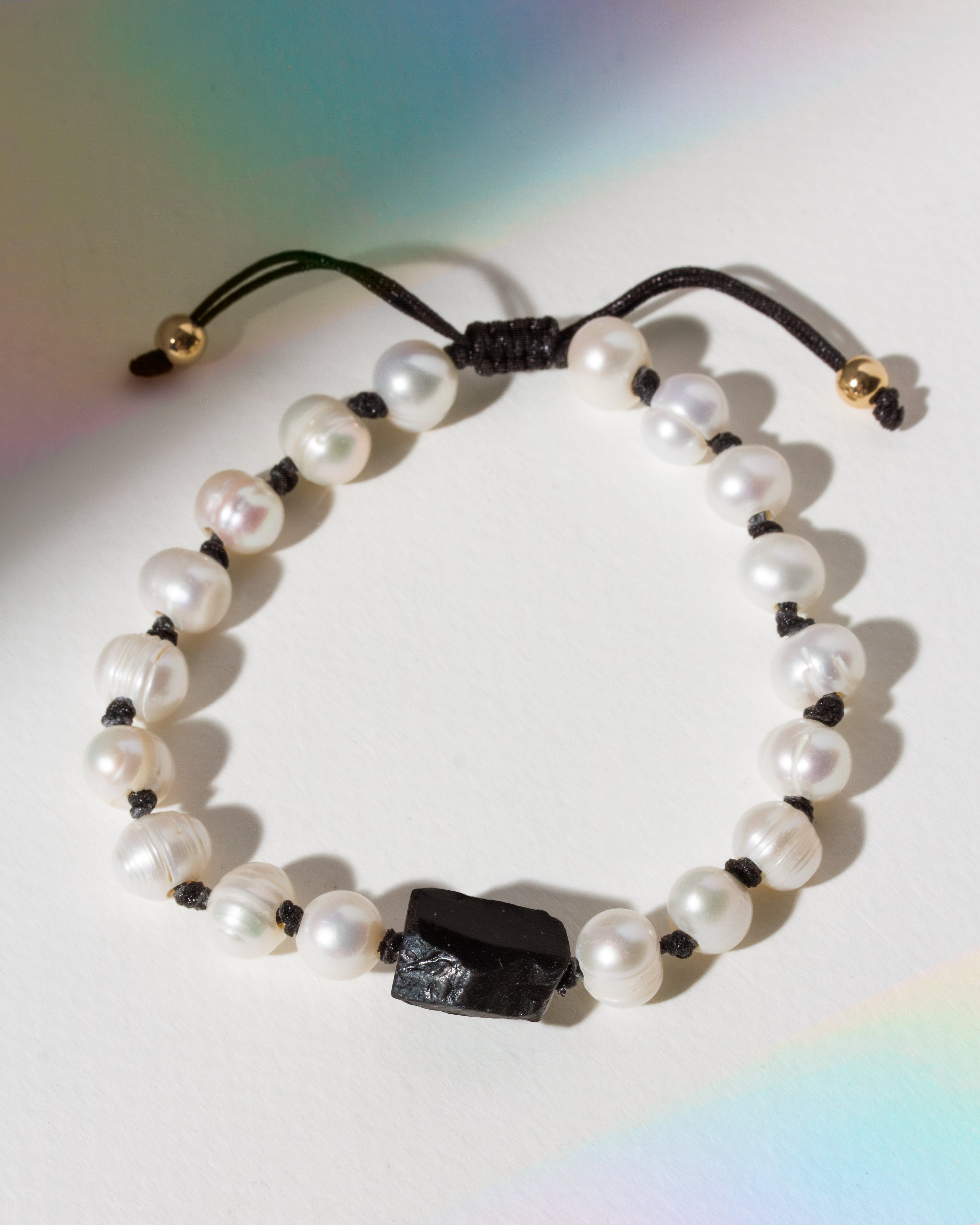 Pearl bracelet with black tourmaline stone on a white background