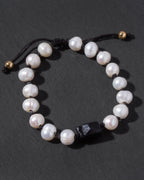 Pearl bracelet with black tourmaline bead on a dark background