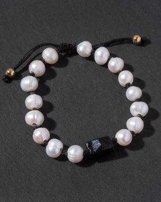 Pearl bracelet with black tourmaline bead on a dark background