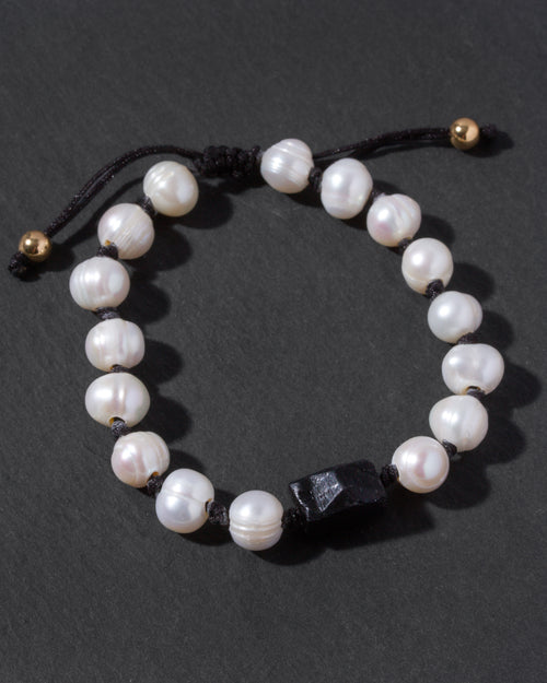 Pearl bracelet with black tourmaline bead on a dark background