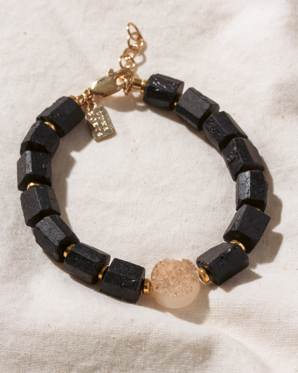 Tourmaline beaded bracelet with peach druzy bead in the center.