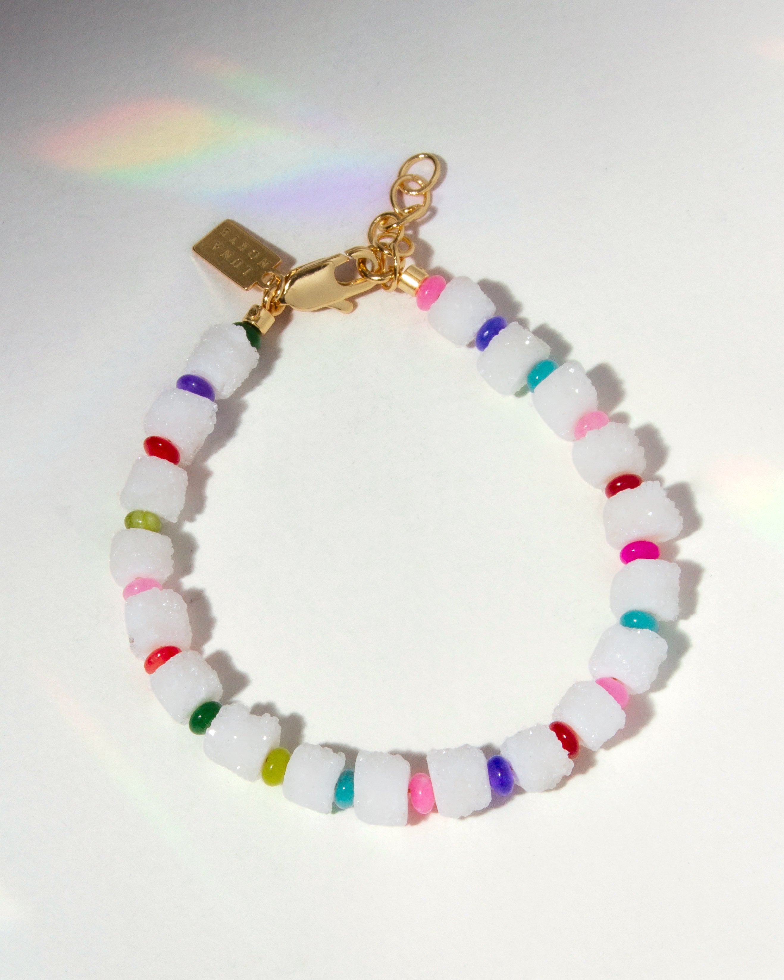 Multicolored beaded bracelet with a gold clasp on a white background