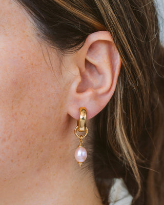 Closeup of woman earring pearl hoop earring.