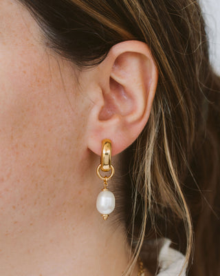 Closeup of woman earring pearl hoop earring.