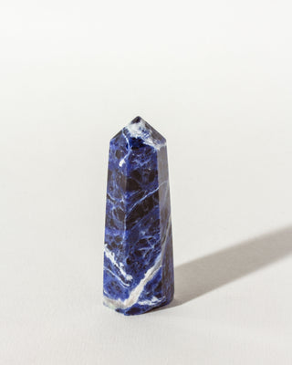 A sodalite mini gemstone tower with a chiseled design, displaying natural blue and white patterns.