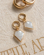 Pair of gold interchangeable hoop earring charms with a moonstone, resembling a diamond