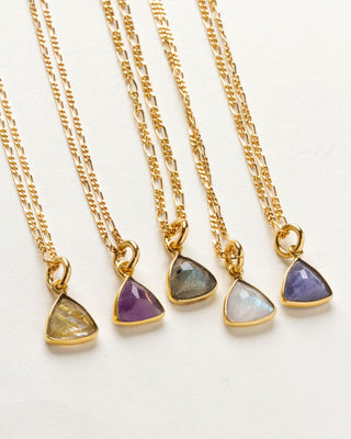 A collection of triangular gemstone pendant necklaces in various colors, each with a gold chain and clasp, displayed against a white background.