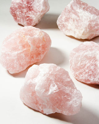 Close-up of pink natural rose quartz rocks on a white background