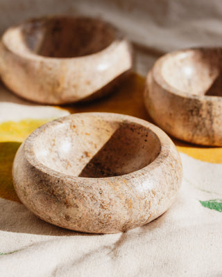 Three calcite jewelry catchall bowls on a floral motif cloth.