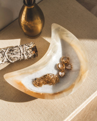 A moon-shaped catch-all dish, carved from genuine calcite, displayed on a light background with shadows.