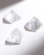 Three clear crystal pyramids on a white background.