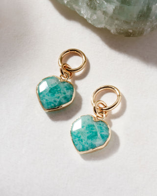 A pair of interchangeable hoop earring charms with heart shaped amazonite gemstone displayed on a white surface.