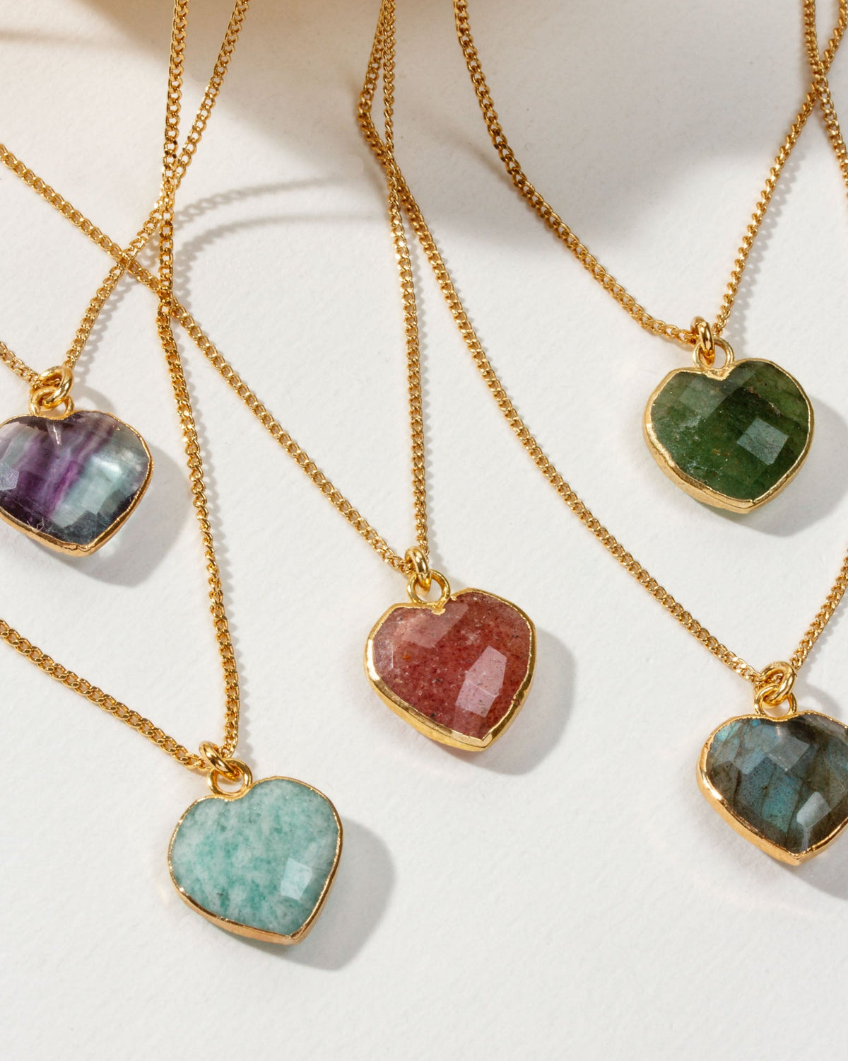 Collection of heart-shaped gemstone gold chain necklaces in various colors