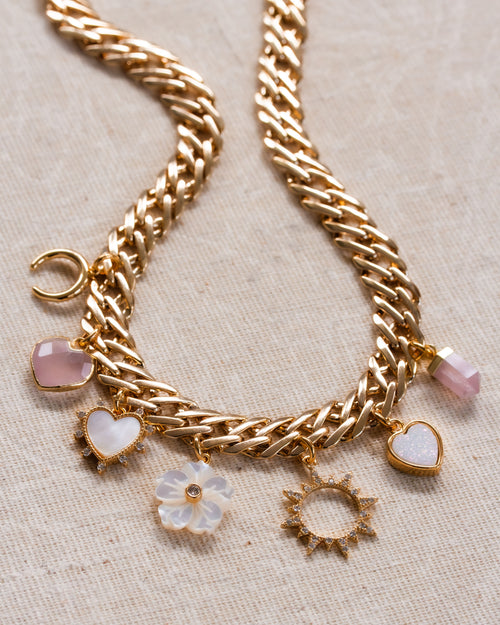 A chunky gold chain charm necklace with rose quartz, mother-of-pearl, and druzy charms