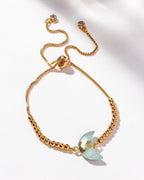 Gold adjustable bracelet with crescent aquamarine centerpiece, CZ crystals, and small gold beads