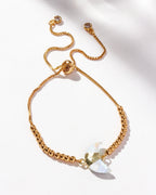 Gold adjustable bracelet with crescent moonstone centerpiece, CZ crystals, and small gold beads