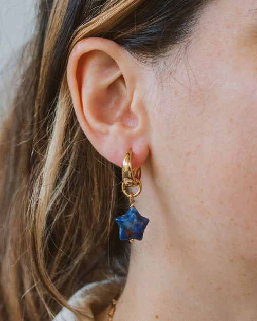 Closeup of person wearing blue sodalite hoop earring