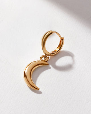 A single gold-colored hoop earring with a moon-like design, made of 14kt gold plated brass, displayed against a white background.