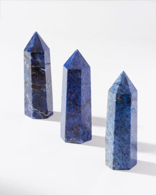 Three Dumortierite obelisks arranged on a white background.