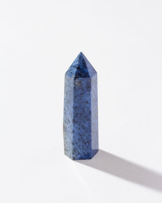 Single Dumortierite faceted gemstone tower standing on a white background.