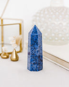 A polished dumortierite crystal tower with rich, denim-blue tones and natural variations