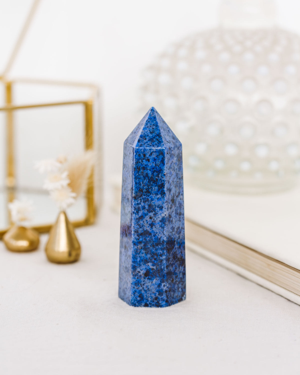 A polished dumortierite crystal tower with rich, denim-blue tones and natural variations