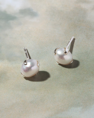 A pair of silver stud earrings with white freshwater pearls.