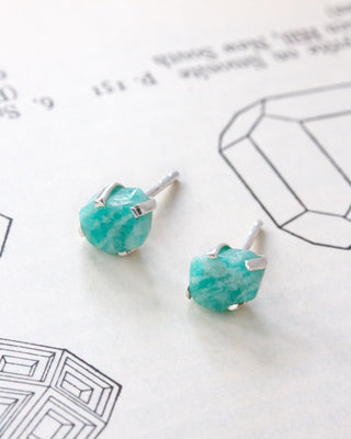 A pair of stud earrings with light blue-green amazonite stones in silver settings.