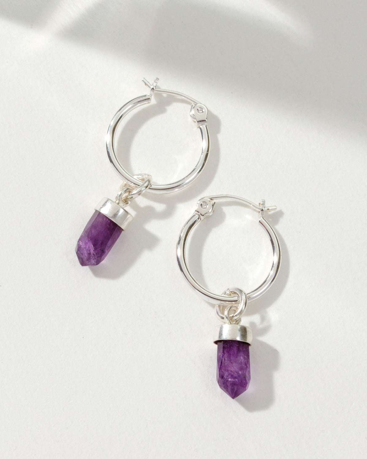 Silver mini hoop earrings with Amethyst stone pendants.