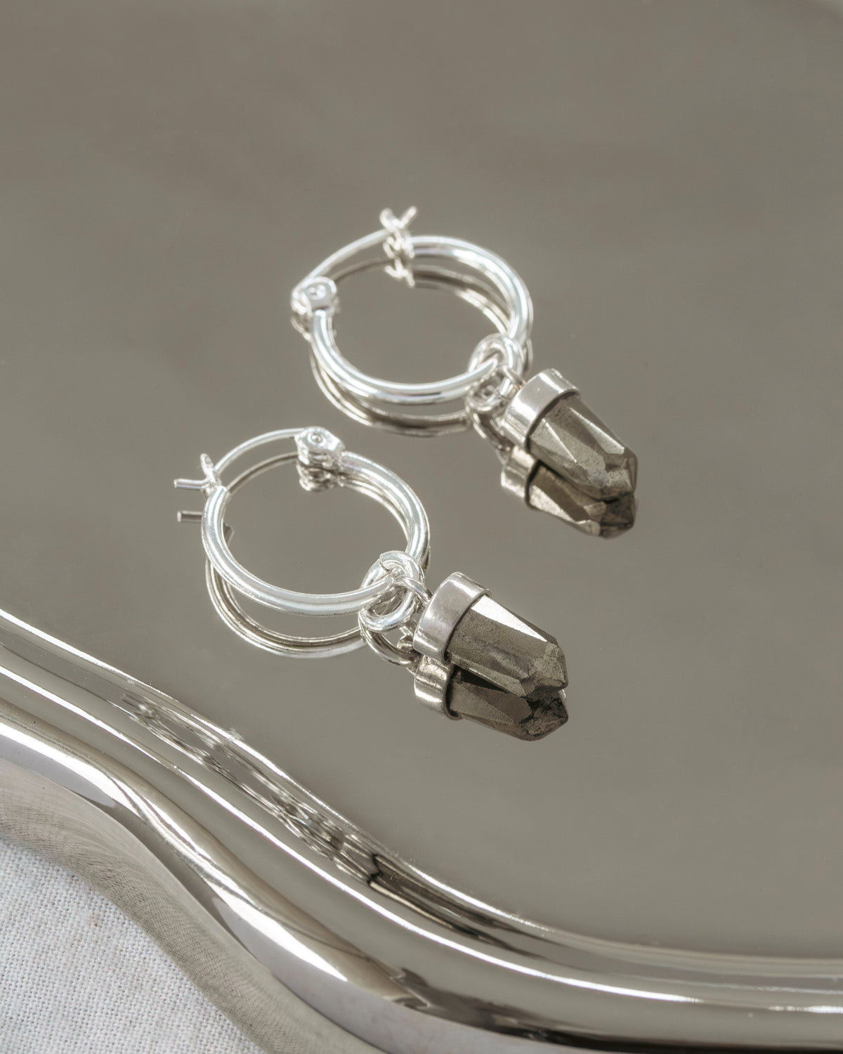Silver hoop earring with pyrite charms.
