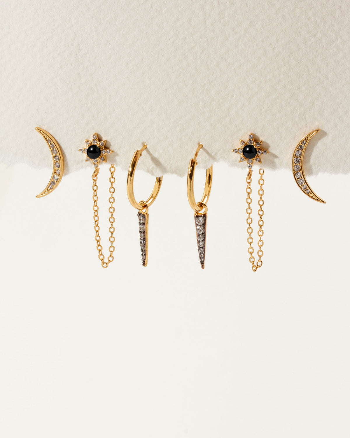 The Twilight Earring Set features moon, spike and onyx starburst gold earrings with clear gemstones.