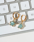 Gold hoop earrings with star-shaped light blue aquamarine stone charms.