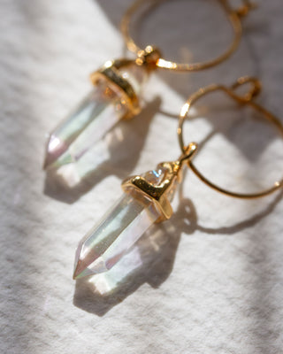 Gold hoop earrings with tapered iridescent crystal pendants.