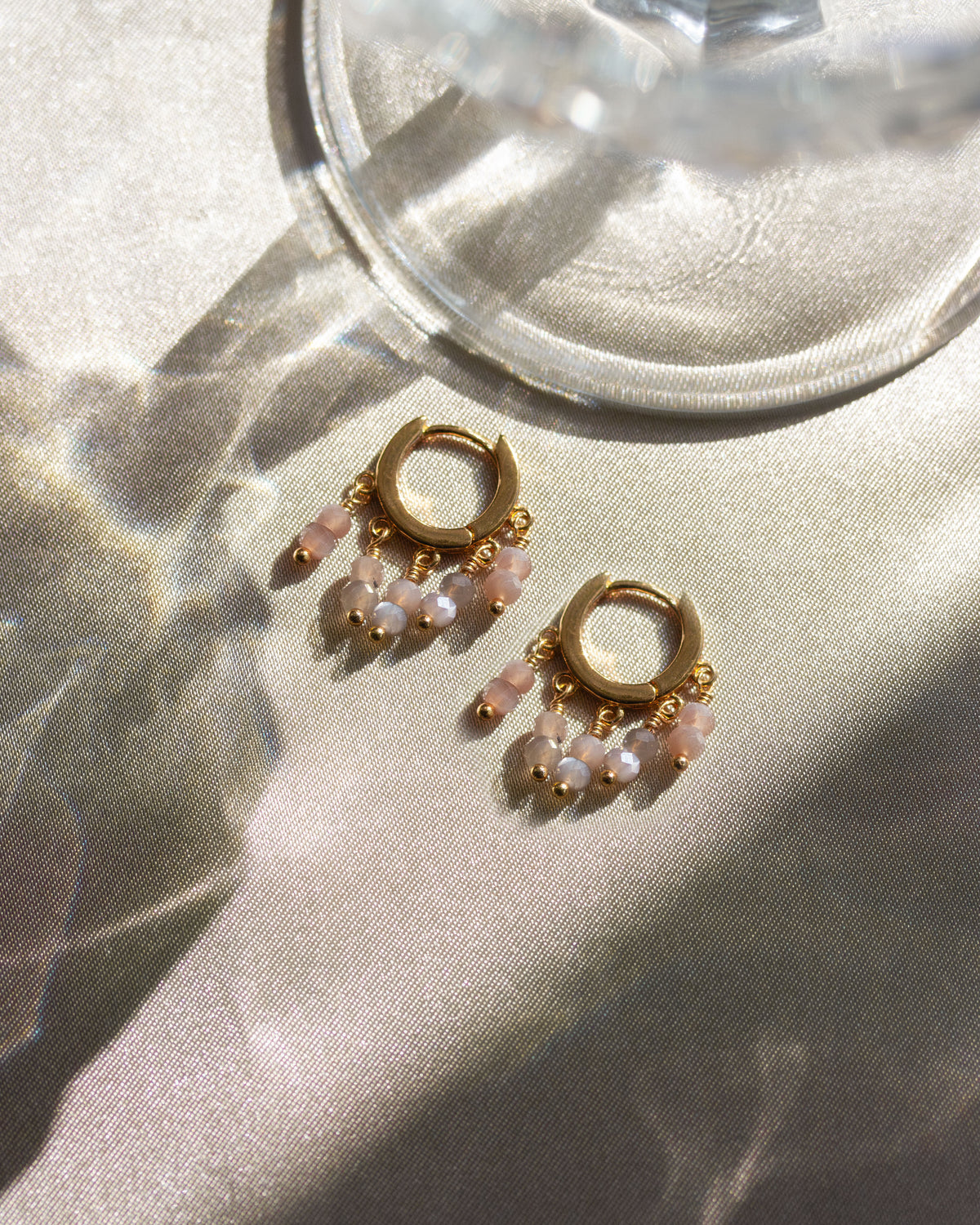 Pair of gold huggie hoop earrings with coffee moonstone drops